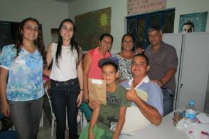 Representantes do CRAS e COHAB-Minas junto de uma das famílias beneficiadas