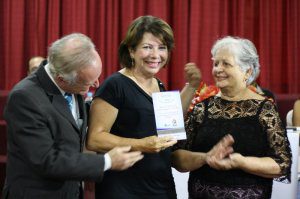 Rina Miranda Grossi Barbosa, filha de Dário Grossi, recebe o troféu Sorria Caratinga das mãos de D. Íris Ferraz Junqueira