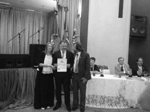 Eugênio recebendo o prêmio pelas mãos do escritor Luiz Poeta e da presidente da Editora Mágico de Oz 