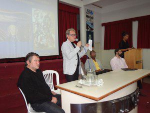 Na ponta da mesa principal, o professor Nelson Sena, com o professor Marco Antônio Gomes, coordenador do curso, fazendo a abertura dos trabalhos