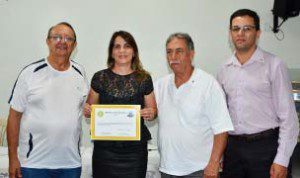 Rotarianos Carlinhos, Narcélio e Walter entregam diploma de participação a Leila